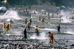 Exxon Valdez oil spill workers use pressure washers to wash oil from the beach on Smith Island, Prince William Sound. The oil was impounded in the water off of the beach and skimmed from the water. Photo by Bob Hallinen, Anchorage Daily News